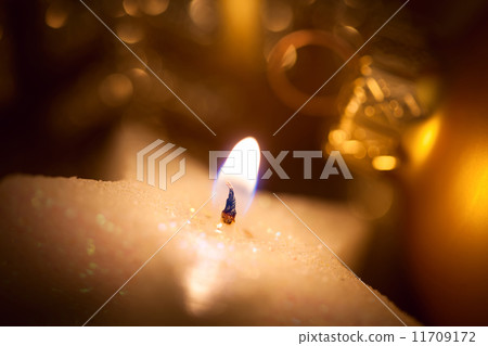 Christmas star-shaped candle with glitter and baubles Christmas star-shaped candle with glitter and baubles 11709172