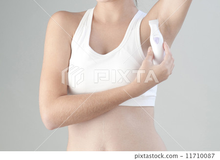 Woman trimming her armpit with electric trimmer 11710087