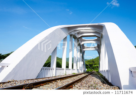 Old white railway bridge constructed against a blue sky in Lamphun, Thailand. 11711674