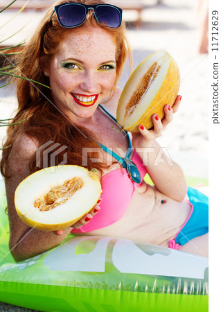 Smiling girl with freckles holding melon 11712629