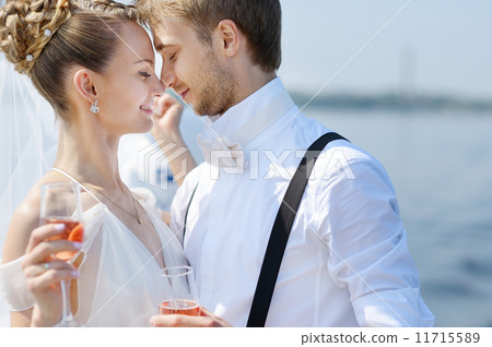 Happy bride and groom drinking champagne 11715589