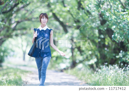 A woman walking on the green road 11717412