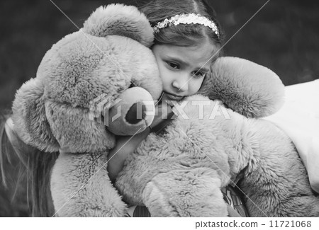 Monochrome portrait of small crying girl hugging teddy bear Monochrome portrait of small crying girl hugging teddy bear 11721068