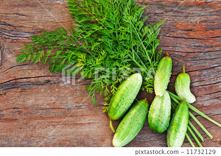 Juicy ripe green cucumbers on old wooden background. 11732129