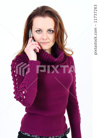 The attractive woman with pullower talks by a mobile phone on a white background The attractive woman with pullower talks by a mobile phone on a white background 11737263