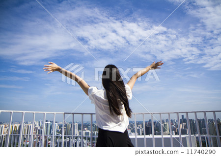 Young woman arms raised enjoying the fresh air 11740290