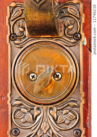 Color photo of a metal handle on a wooden door 11746216