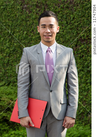 Portrait of a young Asian businessman outdoors 11747984