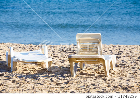 two old sunloungers on tunisian beach 11748259