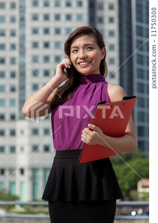 Young Asian businesswoman using cellphone outdoor Young Asian businesswoman using cellphone outdoor 11750308