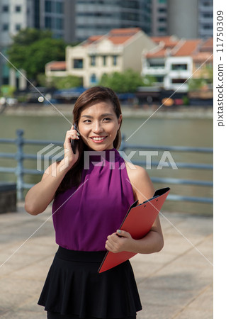 Young Asian businesswoman using cellphone outdoor Young Asian businesswoman using cellphone outdoor 11750309
