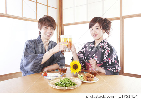 A man and a woman in a yukata that toast a beer in a Japanese style room A man and a woman in a yukata that toast a beer in a Japanese style room 11751414