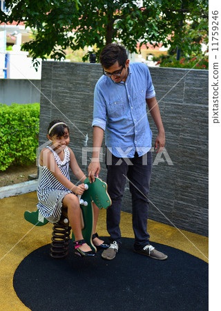 Asian indian bother accompanying his young sister at the playground Asian indian bother accompanying his young sister at the playground 11759246