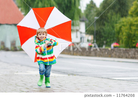 Beautiful child with yellow umbrella and colorful jacket outdoor 11764208