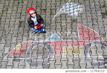 Little boy having fun with race car picture drawing with chalk 11764210