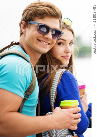 Couple tourists with map and coffee cups near river in a city 11802495