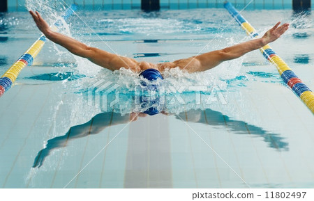 Young man in swimming cap and goggles swim using breaststroke technique 11802497