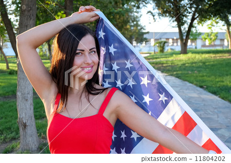 Happy young woman holding american flag 11804202