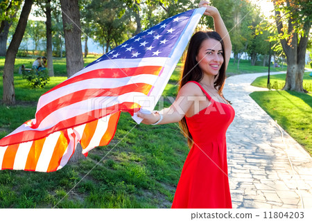 Happy young woman holding american flag. Cute female in red dres Happy young woman holding american flag. Cute female in red dres 11804203