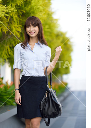 Successful young office lady going to work walking along promenade shallow dept of field Successful young office lady going to work walking along promenade shallow dept of field 11805060