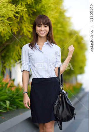Successful young office lady going to work walking along promenade shallow dept of field 11805149