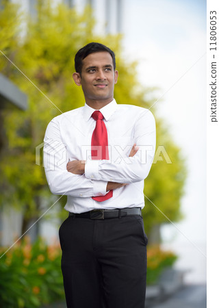 Portrait of successful young Indian corporate executive standing along promenade Portrait of successful young Indian corporate executive standing along promenade 11806053