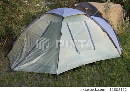 A green tent on a picnic in a forest on a sand with grass A green tent on a picnic in a forest on a sand with grass 11808112