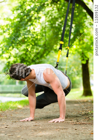 man in city park doing suspension trainer sport 11809132