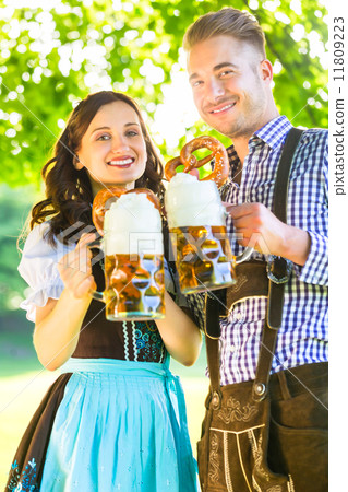 German couple in Tracht drinking beer 11809223