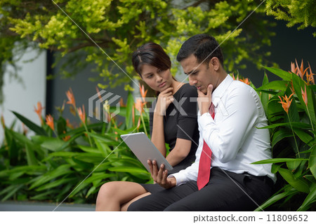 Mix race successful Indian Malay corporate execute meeting using iPad mobile device tablet outdoor Mix race successful Indian Malay corporate execute meeting using iPad mobile device tablet outdoor 11809652