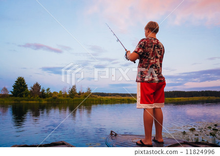 Belarusian Boy Fishing From Old Boats At Sunset Of A Summer Day 11824996