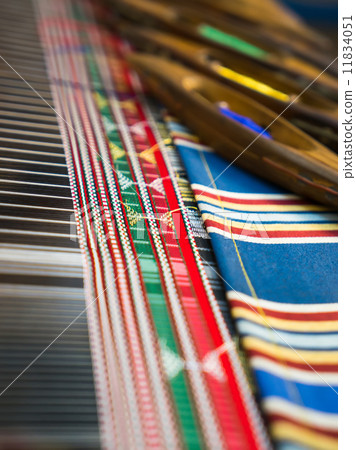 Weaving shuttles and colorful textile with pattern 11834051