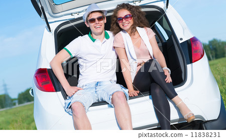young couple sitting in the open trunk 11838231