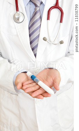 A doctor's hand holding ovulating injector 11838799