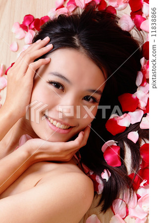 young woman touching her face with rose 11838866