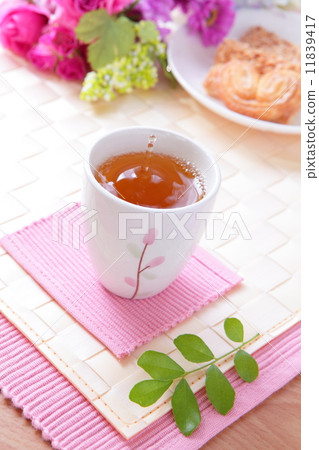 cup of black tea with cookie and beautiful flowers cup of black tea with cookie and beautiful flowers 11839417