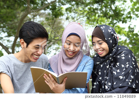 Three Asians watching notes in the park Three Asians watching notes in the park 11849889