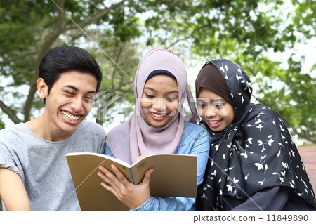 Three Asians watching notes in the park 11849890
