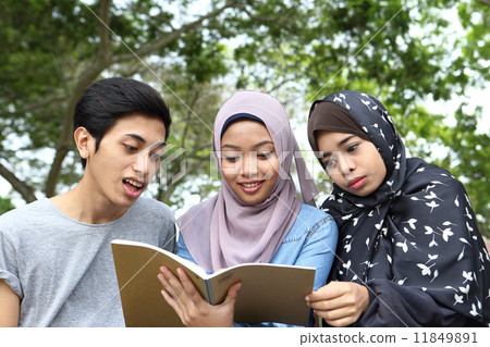 Three Asians watching notes in the park Three Asians watching notes in the park 11849891