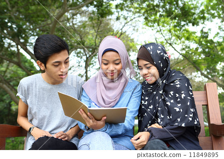 Three Asians watching notes in the park Three Asians watching notes in the park 11849895