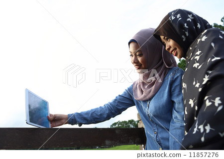 觀看片劑的兩個亞洲人在公園 11857276