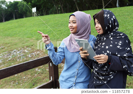 觀看片劑的兩個亞洲人在公園 11857278