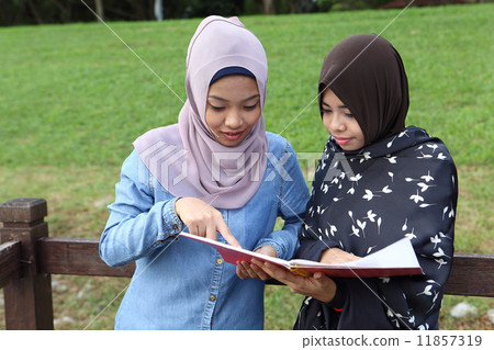 觀看筆記的兩個亞洲人在公園 11857319