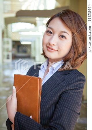 一套衣服的婦女與看照相機的筆記本或筆記本 一套衣服的婦女與看照相機的筆記本或筆記本 11858464