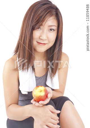Young and fit pretty girl in exercise outfit holding red apple 11859486