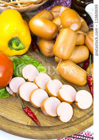 sausages on a wooden plate with vegetables in a restaurant 11860699