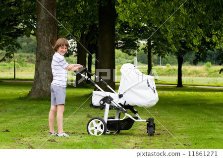 Big brother pushing a stroller in the park  11861271