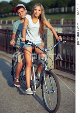 Happy couple riding a bicycle in the city street Happy couple riding a bicycle in the city street 11863602