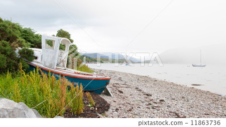 Small shipwreck at a loch with stone beach Small shipwreck at a loch with stone beach 11863736