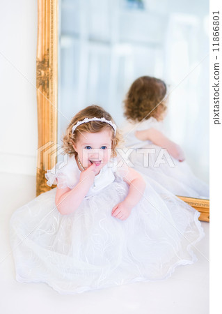 Little girl in a white dress next to a mirror Little girl in a white dress next to a mirror 11866801
